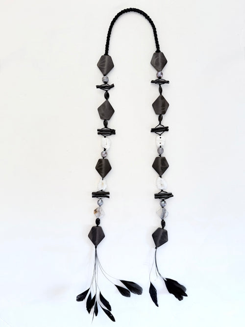Ritualistic. Tribal Modern aesthetic. Unique piece long open drop necklace, handmadein Lebanon with materials sourced worldwide.Black geometric shapes, pearls,onyx,black coral, druzy quartz and feather tassels.Raw materials. Double feather pendants. Sophisticated, collectible, wearable artifact.