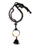 Black adjustable cotton braided threads with a double strand of lampwork magatama and oval shaped beads. Onyx stones, carved horn, an African wax fabric bracelet Finished with an antique Ottoman tassel.