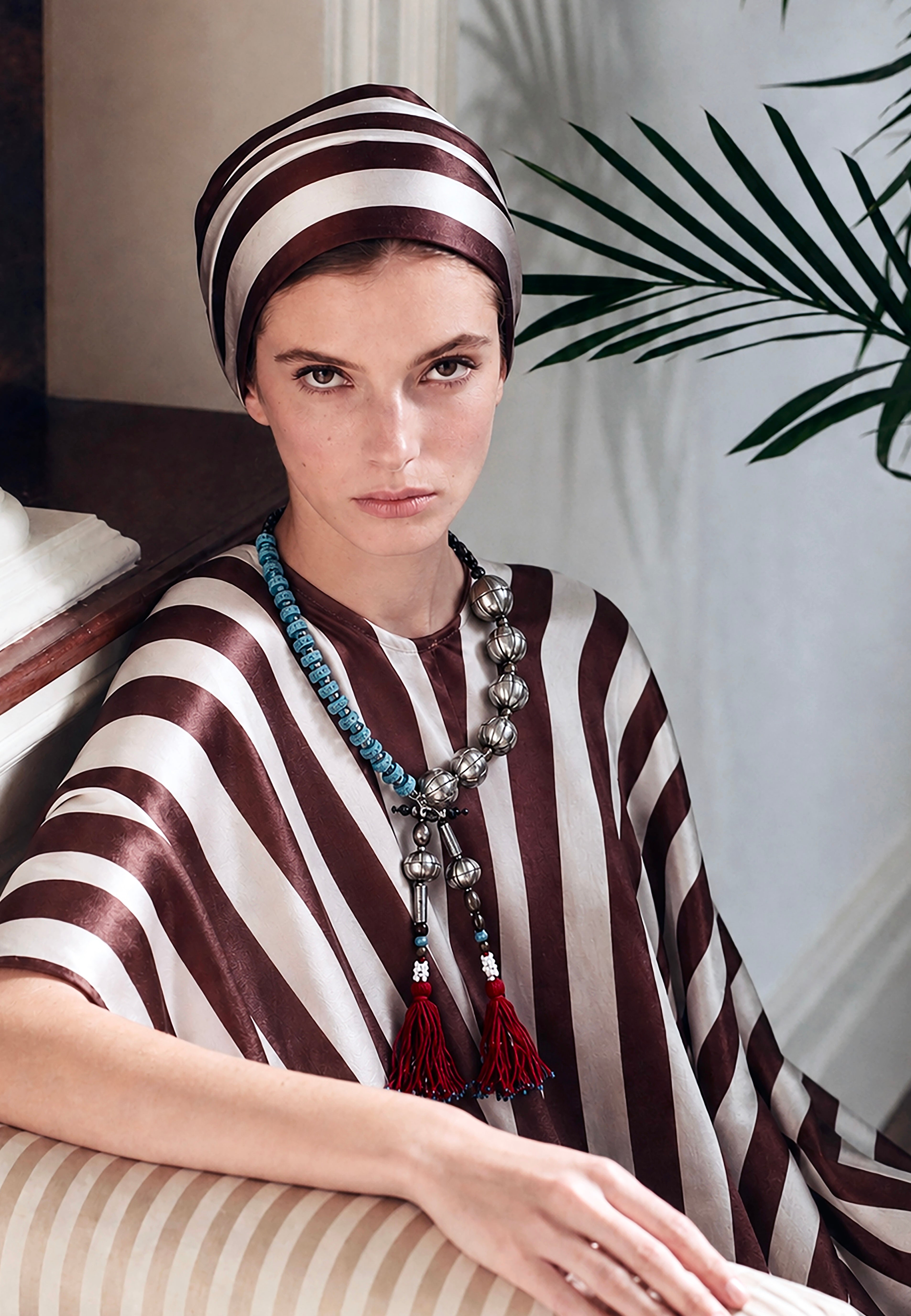 Pièce unique necklace, handmade in Lebanon with adjustable braided cotton threads, metal, ceramics, lava beads and aquamarine stones. Finished with deep Ottoman crimson tassels.

Raw elements. Refined construction.
