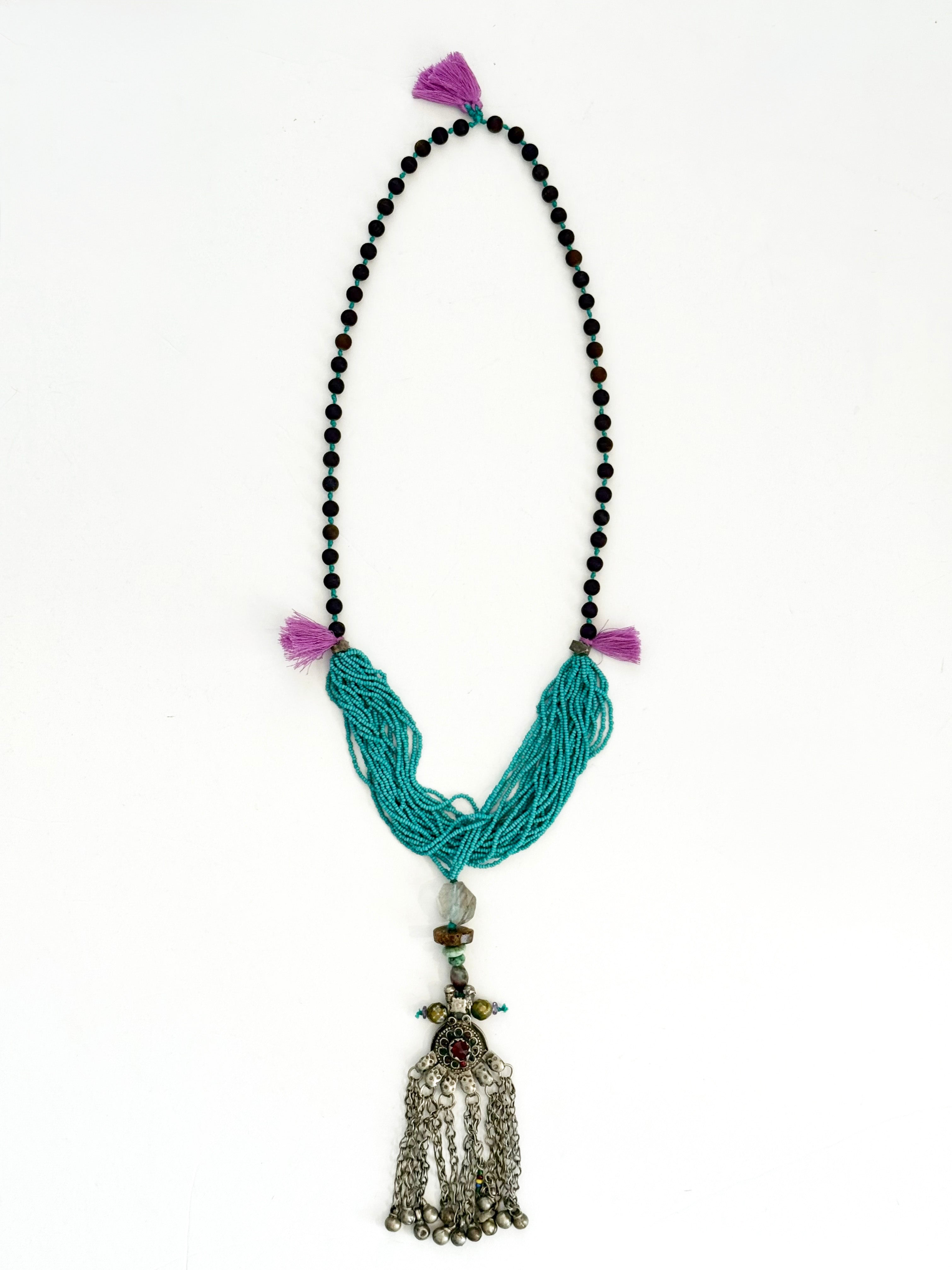 Ancient routes. Modern hands.
Pièce unique handmade in Lebanon with braided cotton thread, turquoise micro beads, druzy agates and mixed stones. At its heart, an antique silver Kuchi pendant, symbol of identity, protection, and wealth.
Free spirited, Worn across borders ...